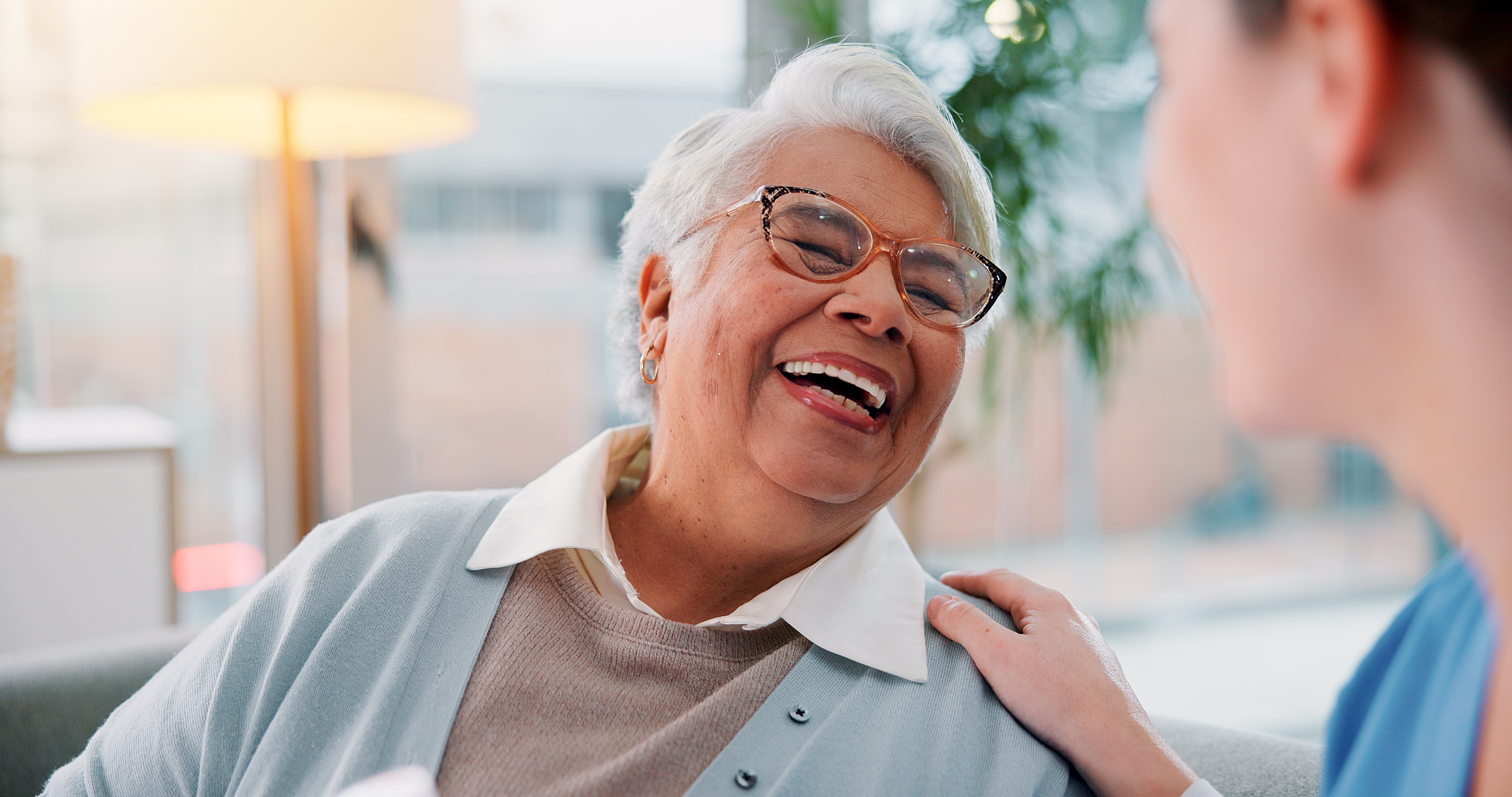 Older adult smiling while talking with a clinician about treatment options.