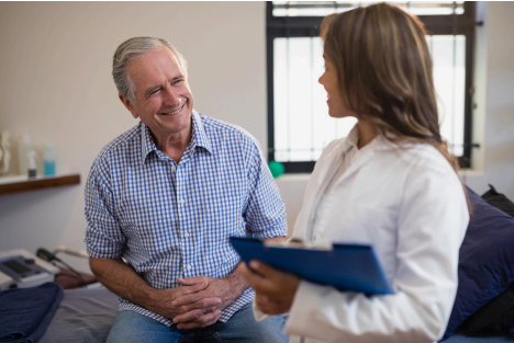 Patient smiling while speaking with physician before a procedure.